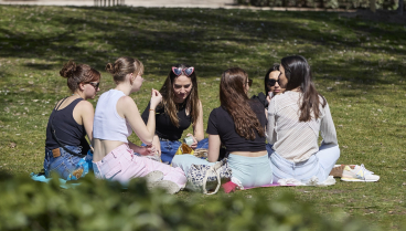 Unas chicas conversan y comen algo el Parque del Retiro