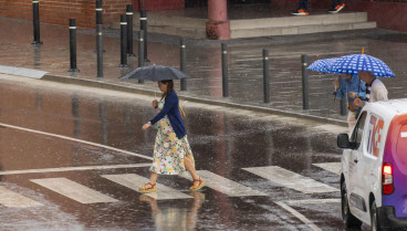 Varias personas se protegen de la lluvia a primera hora en Teruel