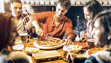 Grupo de amigos comiendo pizza