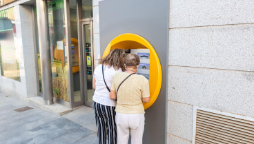 Dos mujeres jubiladas sacando dinero de un cajero automático