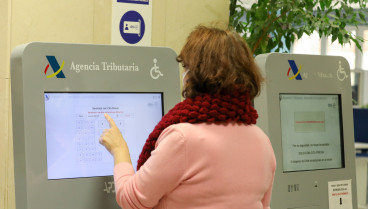 Una mujer recoge su turno en una oficina de la Agencia Tributaria