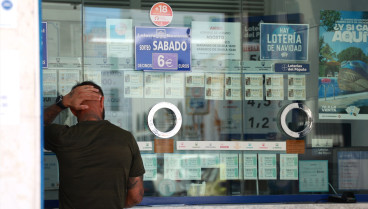 Una persona se dispone a adquierir un boleto en una Administración de Loterias, en el centro de Sevilla