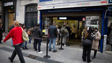 Varias personas hacen cola en la administración de Lotería de Doña Manolita, a 12 de octubre de 2024, en Madrid