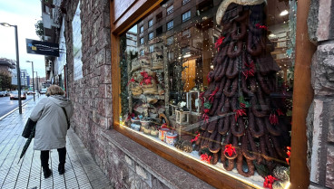 Árbol de Navidad hecho con chorizos y guindillas en el escaparate de una tienda de embutidos de Gijón