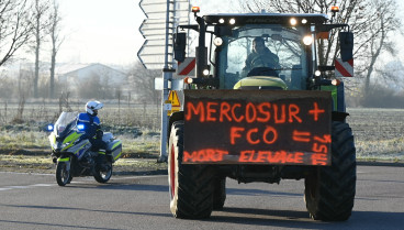 Un agricultor protesta con su tractor, mostrando un cartel contra el acuerdo Mercosur-UE