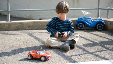 Niño jugando con un coche telederigido