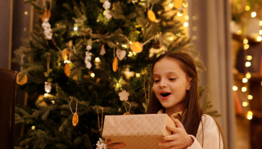 Una niña recibiendo los regalos de Navidad