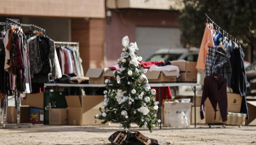 GRAFCVA4184. PAIPORTA (VALENCIA), 06/12/2024.- Un pequeño arbol de Navidad permanece en el centro de un plaza junto a la calle Maestro Serrano de Paiporta junto a la ropa que ha traído un grupo de voluntarios. EFE/Manuel Bruque