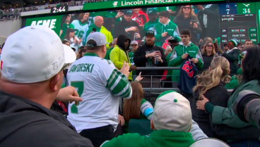 El aficionado que atrapó el balón habla con un miembro de los Eagles.