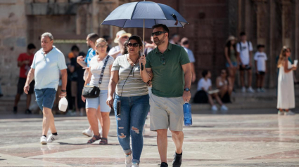 Dos personas con un paraguas para protegerse por el calor