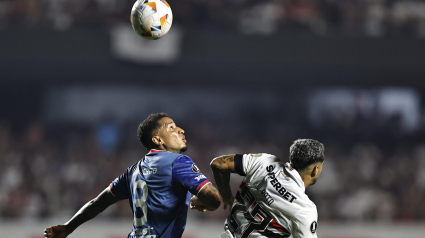 Juan Izquierdo disputa un balón con un rival durante un partido.