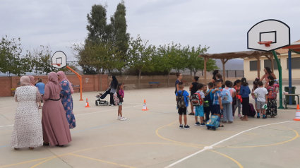 Un grupo de madres y otro de alumnos en el patio de un colegio público en Lorca