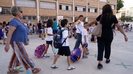 Niños y padres hacen cola para entrar al colegio el primer día de clase tras las vacaciones de verano