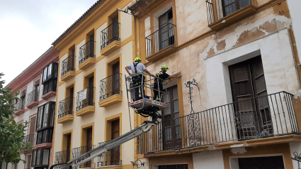 Operarios del servicio de Emergencias y un técnico de Urbanismo revisan una fachada en altura