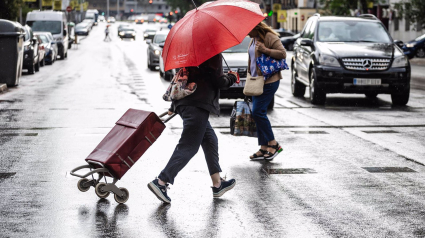 Dos personas caminan bajo la lluvia