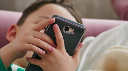 Un niño usando un teléfono móvil