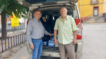 Óscar Acero, alcalde de Bovera (izquierda) junto a un vecino al volver de hacer la compra en su taxi