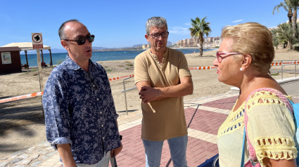 Representantes municipales informan a una mujer del cierre al baño de la playa