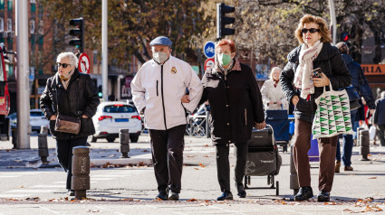 Varias personas con mascarilla pasean por la calle