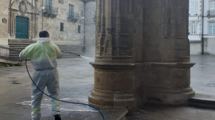 Un operario limpia una de las columnas de la puerta norte de la catedral de Lugo