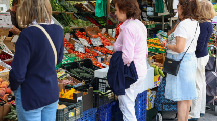 Varias personas esperan en un mercado de la Comunidad de Madrid