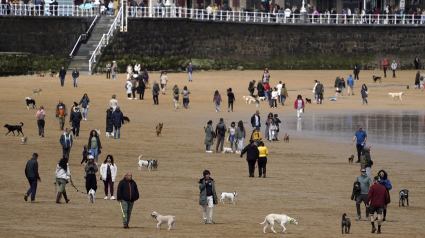 Gente paseando con sus perros en la playa de San Lorenzo de Gijón