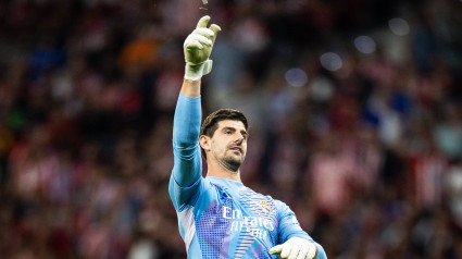 Courtois retira del terreno de juego uno de los mecheros que le lanzaron durante el derbi.