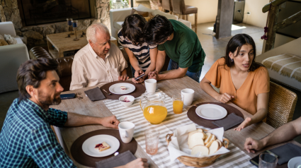 Familia viendo el móvil con el abuelo