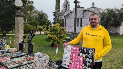 Sergio vende en su puesto a las puertas de la Iglesia de San Caralampio, en A Toxa