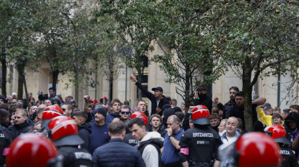 SAN SEBASTIÁN, 03/10/2024.- Agentes de la Ertzaintza vigilan a aficionados del Anderlecht este jueves en San Sebastián, horas antes del partido de la Liga Europa de fútbol entre la Real Sociedad y el Anderlecht. EFE/ Juan Herrero