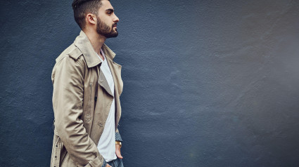 Estilo urbano para el hombre urbano. Imagen de un joven elegante con ropa urbana posando frente a una pared gris.