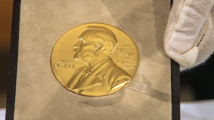 Una mano sostiene la medalla de oro antes de la entrega del Premio Nobel de Física.