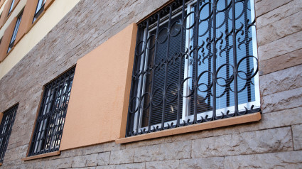 Verjas de hierro forjado adornadas en la planta baja de un edificio de apartamentos en La Laguna, Tenerife, Islas Canarias, España