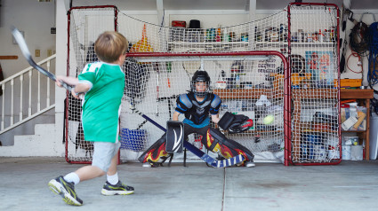 Boys playing hockey in garage