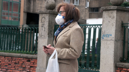 Una mujer se protege con una mascarilla en León