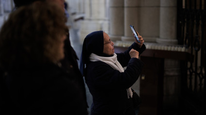 Monja fotografiando con su móvil en una iglesia