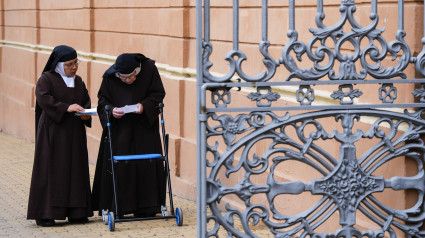 Monjas miran documentos mientras andan por la calle