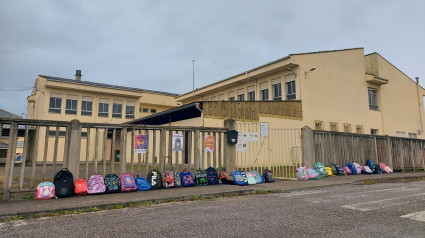 Mochilas colocadas a modo de protesta en la entrada del CEIP Castro de Ouro de Alfoz