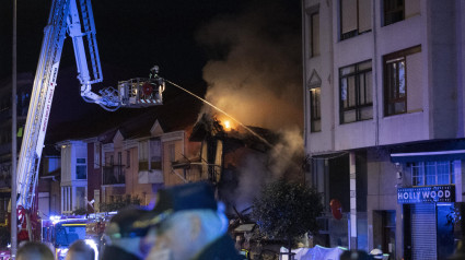 Bomberos de Santander trabajan en la extinción del incendio posterior a una explosión que ha provocado el derrumbe de un edificio de dos plantas