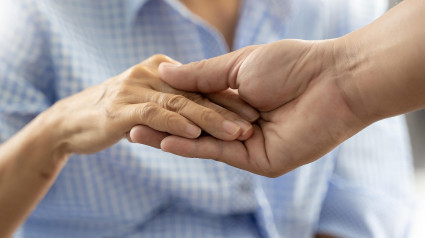 Personas, anciana y joven, tomados de la mano, discapacitados, caminando con ayuda