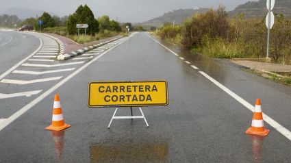 Vista general de la carretera de acceso a Manuel cortada debido a las lluvias torrenciales que afectan a la Comunitat Valenciana, y especialmente a la provincia de Valencia, en la que se ha establecido el aviso rojo