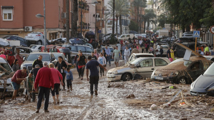 Varias personas caminan por una de las calles afectadas en Paiporta, tras las fuertes lluvias causadas por la DANA. La alcaldesa de Paiporta (Valencia), Maribel Albalat, ha confirmado que al menos hay 34 fallecidos en su municipio a consecuencia de la dana que ha afectado a la Comunidad Valenciana. EFE/Manu Bruque