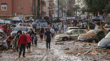 Varias personas caminan por una de las calles afectadas en Paiporta, tras las fuertes lluvias causadas por la DANA. La alcaldesa de Paiporta (Valencia), Maribel Albalat, ha confirmado que al menos hay 34 fallecidos en su municipio a consecuencia de la dana que ha afectado a la Comunidad Valenciana