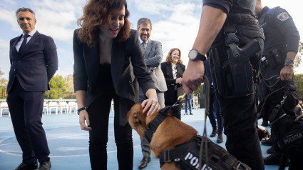 La presidenta de la Comunidad de Madrid, Isabel Díaz Ayuso, acaricia a un perro durante la presentación del Plan Regional contra las Drogas en el Instituto Palas Atenea en Torrejón de Ardoz.