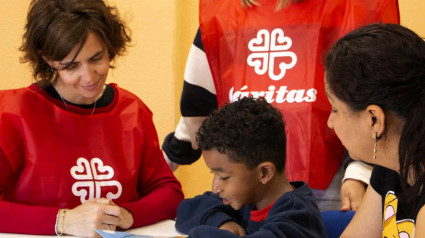 Voluntarias de Cáritas lee con un niño