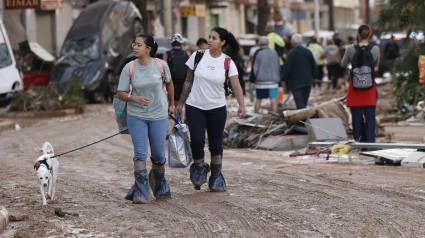 Dos chicas pasean por Paiporta con sus pertenencias y su perro