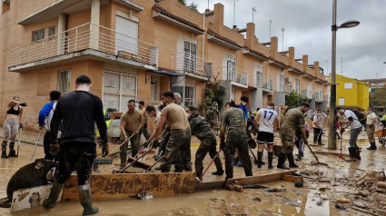 Militares y civiles limpiando una calle en Valencia