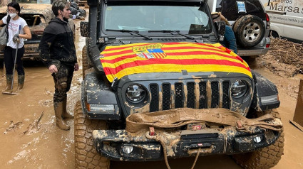 Un coche con la bandera aragonesa circulando entre el barro en Valencia, ícono de WhatsApp del grupo