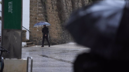 Transeuntes bajo sus paraguas durante la intensa lluvia.