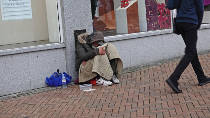 Persona sin hogar pide ayuda en la calle